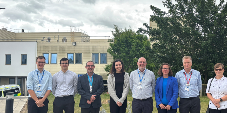 A group of people smiling in the grounds of Milton Keynes Hospital