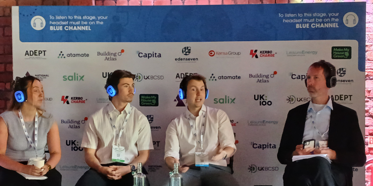 A host and three Salix team members sit on a stage wearing headphones