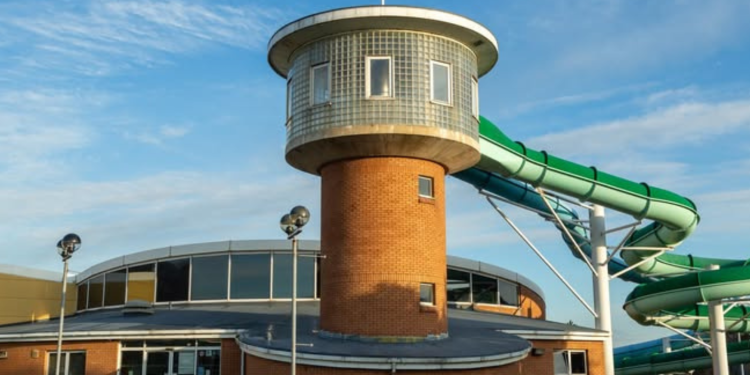 A leisure centre with a green flume coming from a red-brick tower.