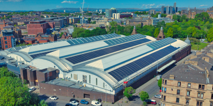 Glasgow from the air with a grand, white building dominating - covered in solar panels.