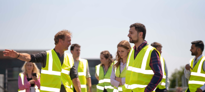 on the roof of the Royal Northern College of Music standing next to roof top solar panels., people walking in high visibility jackets together